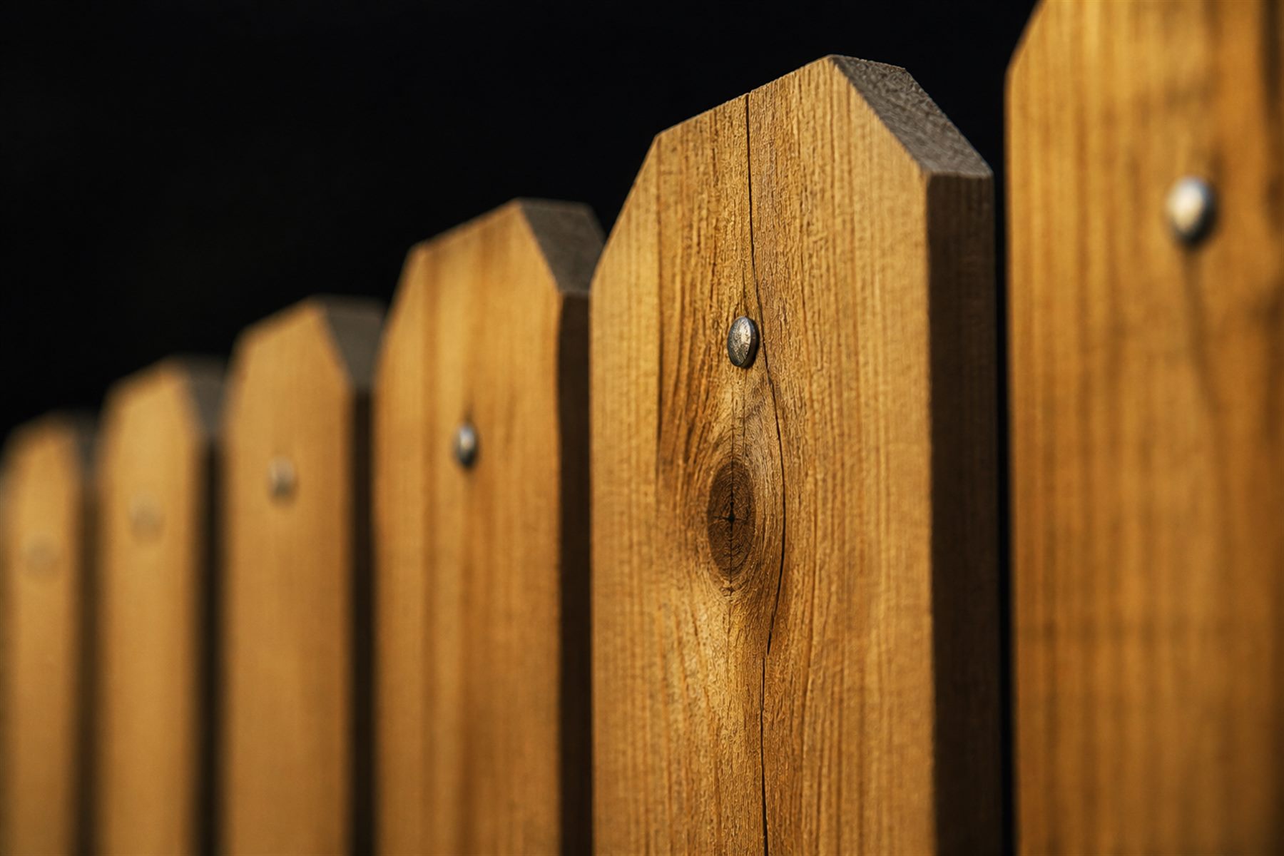 Close-up of cedar picket tops and grain on a finished privacy fence